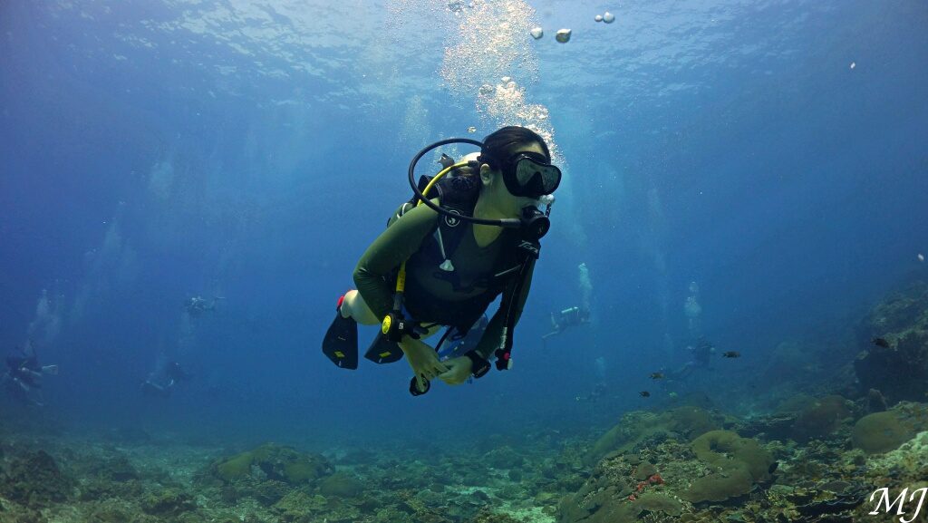 Diver demonstrating neutral buoyancy underwater during an open water dive in Phuket after practicing in the pool