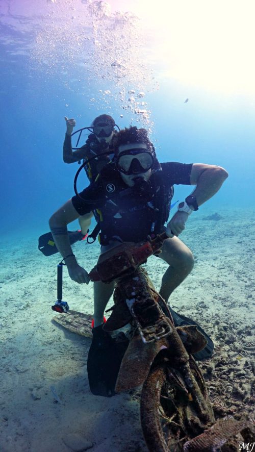 Diver posing on underwater scooter at Racha Yai photo spot.