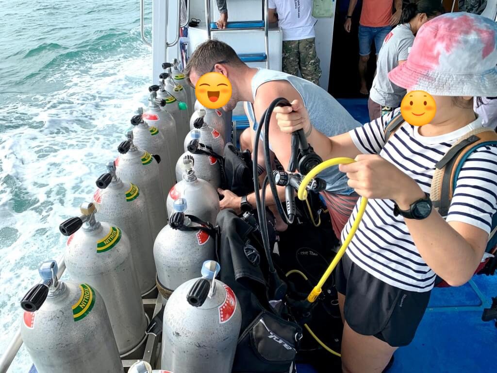 Divers preparing equipment on the boat before starting their Phuket dive trip